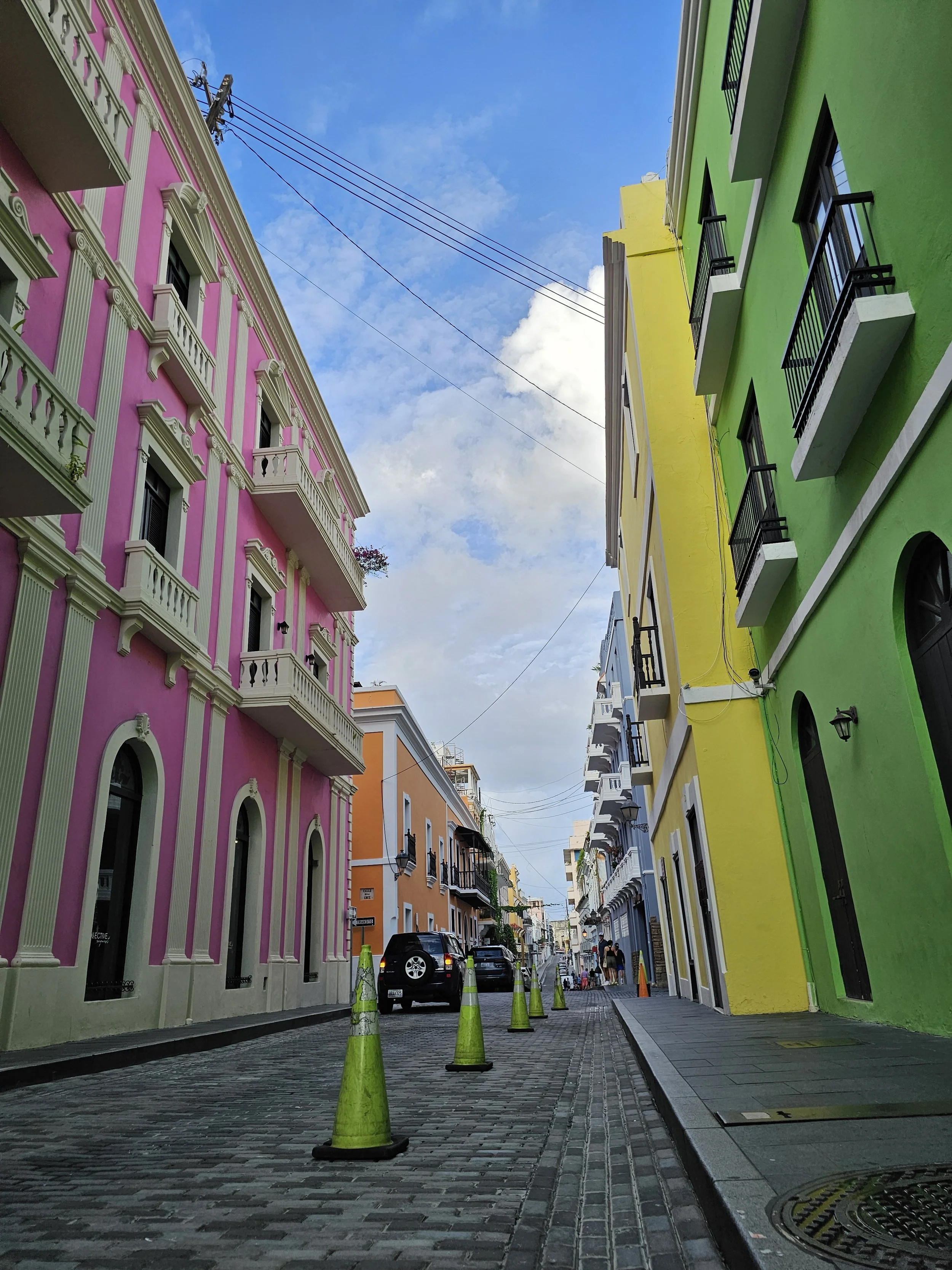Pink, yellow, and green buildings lining a cobbled street