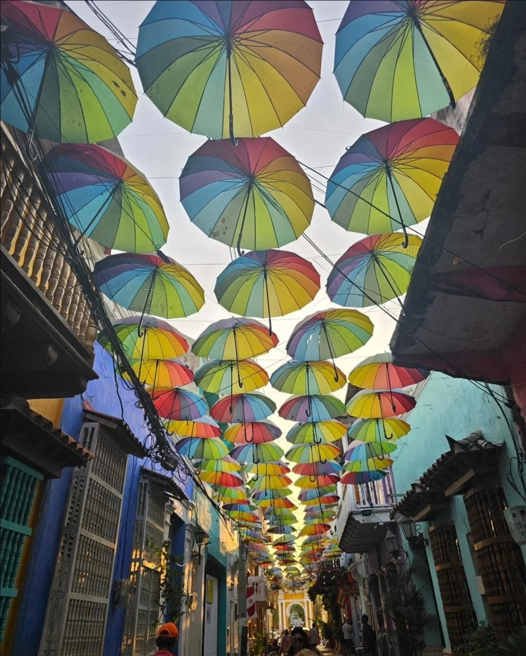 Colorful umbrellas hanging over a narrow street